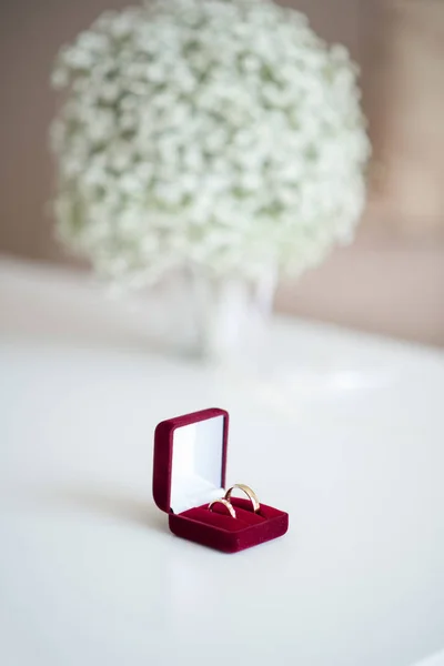Snubní Prsteny Poli Červeném Sametu Svatební Kytici Přes Bílý Stůl — Stock fotografie