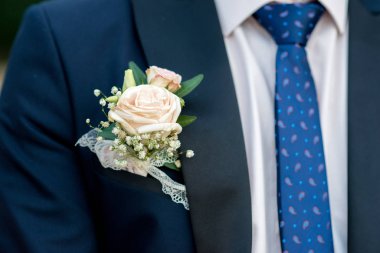 bir damat koyu mavi kostüm ayrıntılı bir ilik gül - seçici odak, metin için yer ile