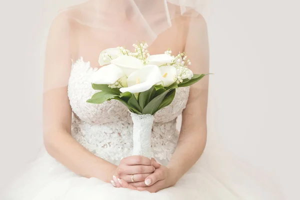 Красива наречена у весільній сукні тримає букет з білої зелені. Білий фон. Простір тексту . — стокове фото