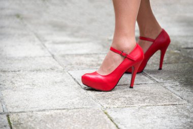 Yüksek topuklu kaldırım döşeme arka planı - seçici odak parlak kırmızı ayakkabı kadın bacakları