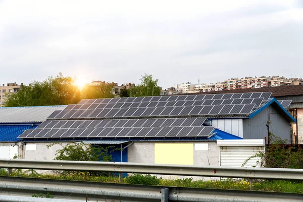 Solar panels, photovoltaics over the roof of an industrial building -  alternative electricity source. Concept of sustainable resources