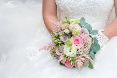 Güzel gelin pembe gül buketi tutan bir gelinlik. Beyaz arka plan. Metin alanı.