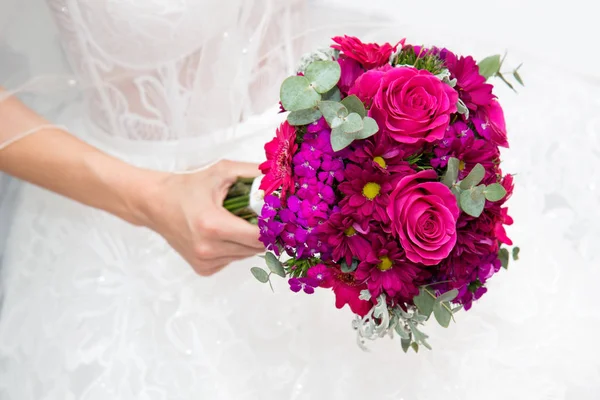 Hermosa novia en un vestido de novia con un ramo de rosas rosadas. Fondo blanco. Espacio de texto . — Foto de Stock