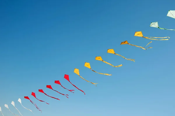 Bunte Drachen fliegen in blauem Himmel — Stockfoto