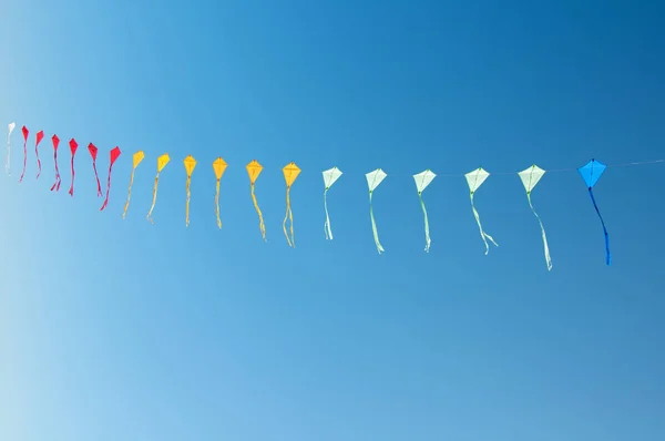 Bunte Drachen fliegen in blauem Himmel — Stockfoto