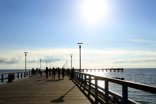 Deniz Köprüsü günbatımı, insanlarla. İn Palanga Baltık denizde yaya köprüsü.