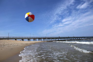 Renkli plaj topu uçuş deniz plaj üzerinde. Tatil plaj topu ufuk Bridge'de Palanga Baltık Denizi Beach gökyüzü.