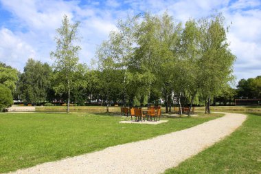 Yolu Şehir Parkı yaz aylarında aracılığıyla. Satranç tahtası tablolarla Parkı doğal görünümünü. Parkta piknik alanı.