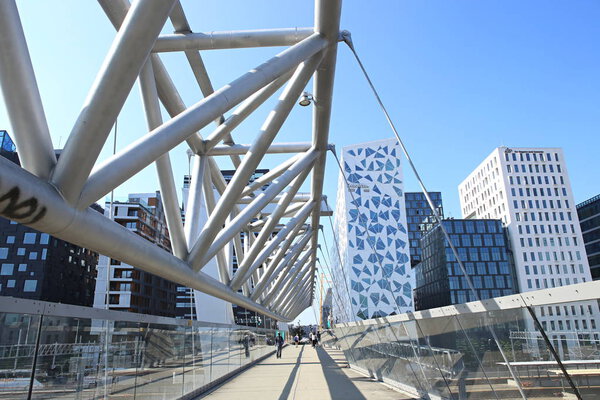 Oslo, Norway  July 19, 2018: Akrobaten pedestrian bridge in Bjorvika district. Modern business architecture in the center of Oslo.  Bridge across the tracks of Oslo central station.