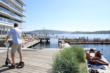 Oslo, Norveç - 24 Temmuz 2018: Yüzme Plaj şehir merkezinde, Tjuvholmen mahalle. Tjuvholmen şehir beach: insanlar yüzme, yaz güneşiyle tahta üzerinde rahatlatıcı.