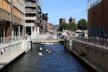Oslo, Norveç - 24 Temmuz 2018: Görünümünü Astrup Fearnley Tjuvholmen sanat bölgesinde Modern Sanat Müzesi. Astrup Fearnley müze alanı çevresi, kanal Müzesi binalar ve paddleboarding insanlar arasında.