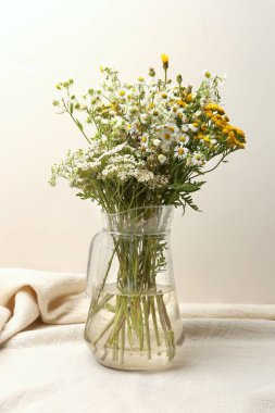 Vazo ile kır çiçekleri buketi. Cam sürahi kır çiçekleri buketi.