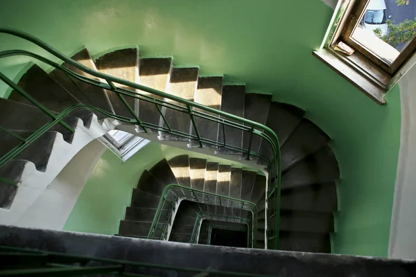 Downward spiral vintage staircase in old building. Indoor residential staircase, built in 1930, Kaunas, Lithuania.