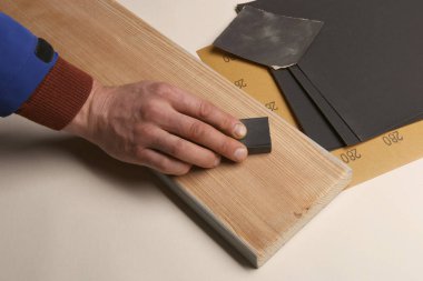 Adam el ahşap kurulu zımpara kullanarak yumuşatma. Zımparalama ve parlatma ahşap melez (bitki) plank.