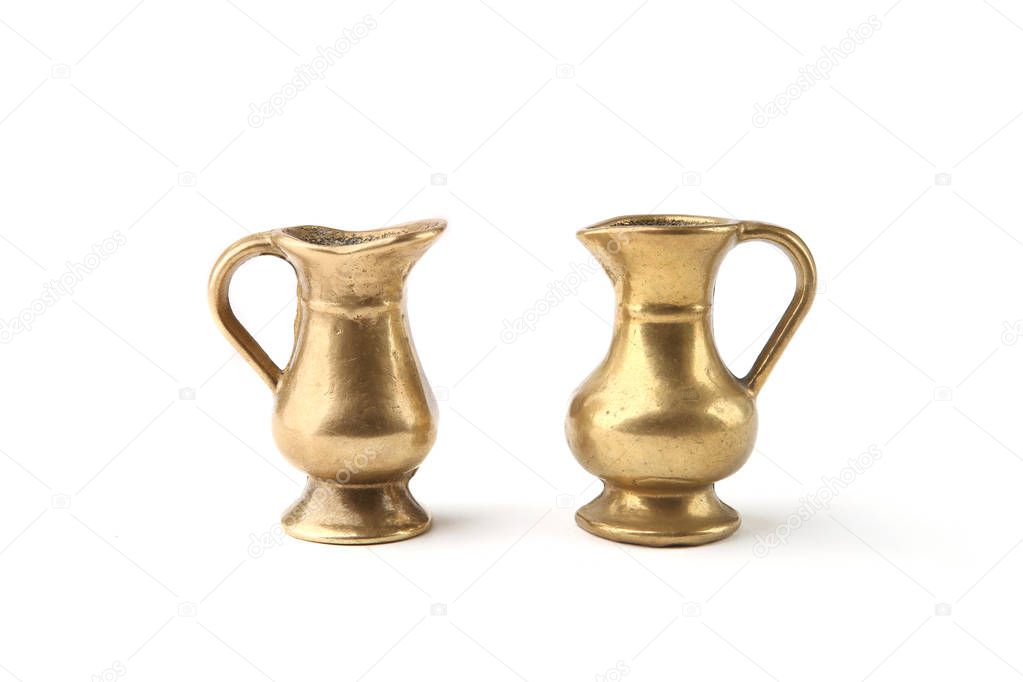 Small golden metal  decorative jugs isolated on white background. Two vintage gold vase pitchers.