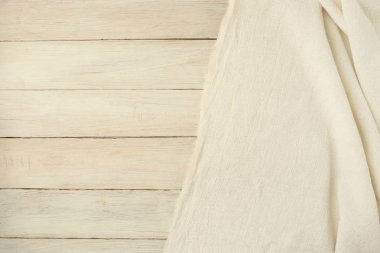 Ahşap arka plan bej dokuma tekstil örtü. Sallayarak bez kumaş tuval üzerine beyaz planking boş yer ile.