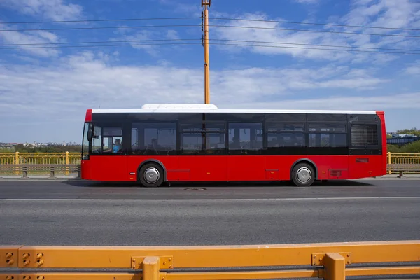 城市巴士过桥 红色巴士在公路上行驶 反对橙色屏障或护栏 — 图库照片
