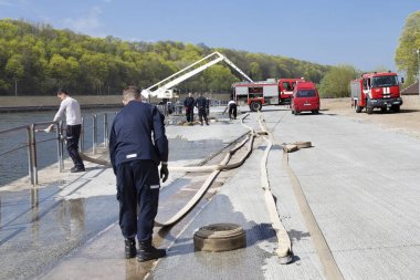 Kaunas, Litvanya Nisan 25, 2019: Acil bir tatbikat sırasında itfaiye. İtfaiyeciler nehir kenarında ki yangın hortumlarını test ediyorlar..