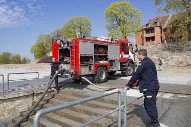 Kaunas, Litvanya Nisan 25, 2019: Acil bir tatbikat sırasında itfaiye. İtfaiyeciler nehir kenarında ki yangın hortumlarını test ediyorlar..