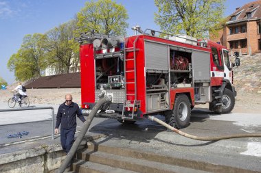 Kaunas, Litvanya Nisan 25, 2019: Acil bir tatbikat sırasında itfaiye. İtfaiyeciler nehir kenarında ki yangın hortumlarını test ediyorlar..