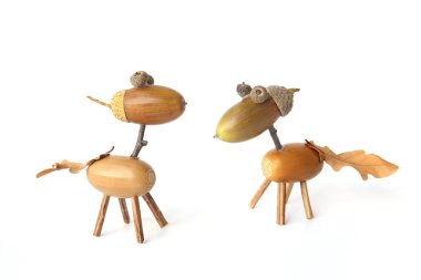 Beyaz arka plan üzerinde izole meşe palamudu yapılmış sevimli küçük atlar. Sonbaharda palamuttan yapılan yaratıcı komik hayvan figürleri.