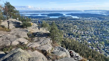 Oslo, Norveç 29 Eylül 2019: İnsanlar sonbaharın başlarında Kolsastoppen dağından Oslo Fjord 'a panoramik manzaranın keyfini çıkarıyorlar. Kolsastoppen, Oslo, Berum ve Oslo Fjord 'un muhteşem panoramik manzaralarıyla tanınan popüler bir yürüyüş alanıdır.