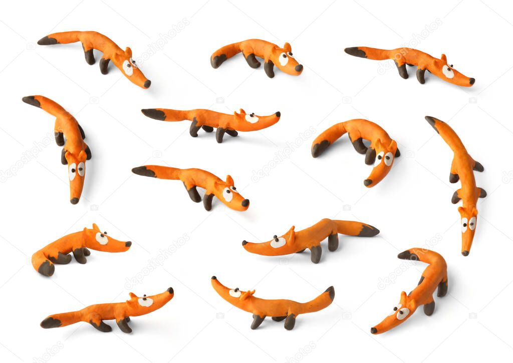 Set of cute foxs made of plasticine isolated on white background. Handmade orange fox figurines of modeling clay