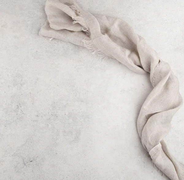Pure washed linen cloth on light grunge stone background. Natural washed linen fabric on stone tile surface with copy space