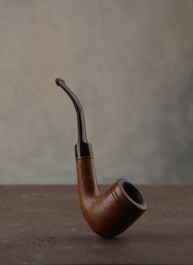 Esmer arka planda sigara piposu içmek. Klasik ahşap tabacco piposu.