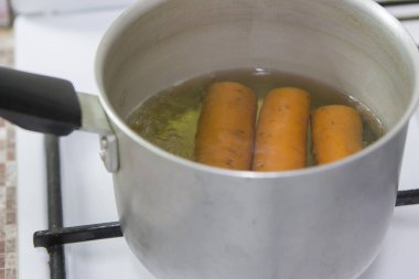 Tava içinde havuç ile gaz sobası üzerinde