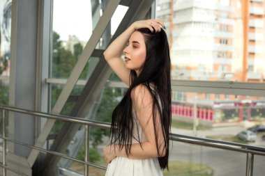 Yazın yaya geçidinde sokakta açık renk bir elbise giymiş güzel bir esmerin portresi.