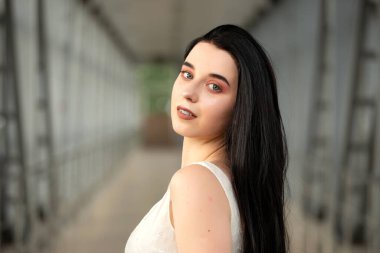 Yazın yaya geçidinde sokakta açık renk bir elbise giymiş güzel bir esmerin portresi.