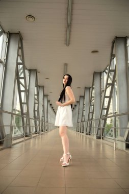 Yazın yaya geçidinde sokakta açık renk bir elbise giymiş güzel bir esmerin portresi.