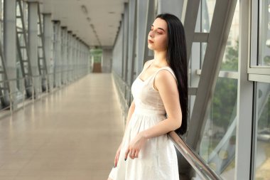 Yazın yaya geçidinde sokakta açık renk bir elbise giymiş güzel bir esmerin portresi.