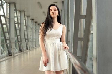 Yazın yaya geçidinde sokakta açık renk bir elbise giymiş güzel bir esmerin portresi.