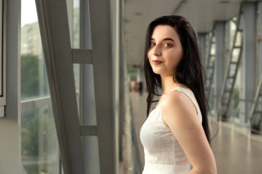 Yazın yaya geçidinde sokakta açık renk bir elbise giymiş güzel bir esmerin portresi.