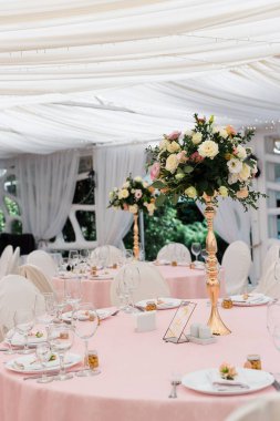 Düğün partisi için çok güzel bir dekor. Çiçek, çeşitli lüks cam ve mum tasarımları. Seçici odaklanma. Muhteşem düğün sandalyesi ve açık havada güzel bir akşam yemeği için sofra hazırlamak muhteşem bir düğün sandalyesi ve açık havada güzel bir yemek için sofra hazırlamak.