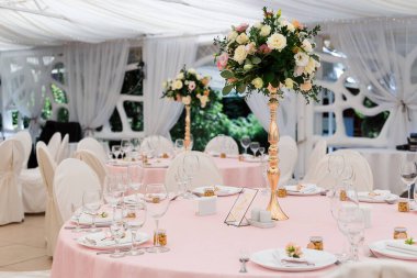 Düğün partisi için çok güzel bir dekor. Çiçek, çeşitli lüks cam ve mum tasarımları. Seçici odaklanma. Muhteşem düğün sandalyesi ve açık havada güzel bir akşam yemeği için sofra hazırlamak muhteşem bir düğün sandalyesi ve açık havada güzel bir yemek için sofra hazırlamak.