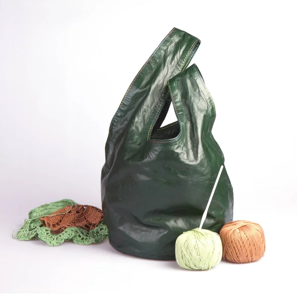 Beyaz arkaplanda örgü torbası olan iplik yumağı