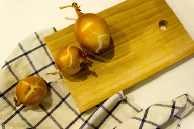 Büyük bir soğan bütünü ve ahşap bir masada kesilmiş soğuk algınlığına karşı sebze kavramı, yatay, yakın plan, kopyalama alanı.