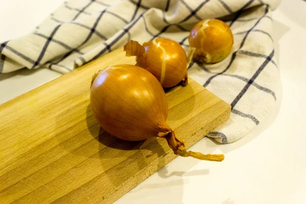 Büyük bir soğan bütünü ve ahşap bir masada kesilmiş soğuk algınlığına karşı sebze kavramı, yatay, yakın plan, kopyalama alanı.