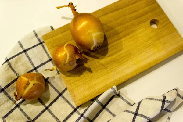 Büyük bir soğan bütünü ve ahşap bir masada kesilmiş soğuk algınlığına karşı sebze kavramı, yatay, yakın plan, kopyalama alanı.