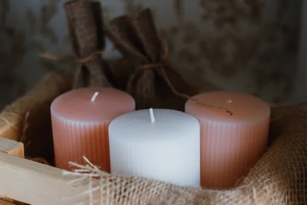 Three burning candles on sackcloth and old wooden boards. Top view. — Stock Photo, Image