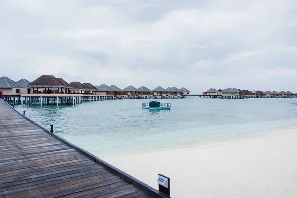 Water Villas and wooden bridge at Tropical beach in the Maldives