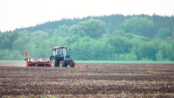 Тракторный завод вспахивает поле перед посадкой урожая в замедленной съемке — стоковое видео