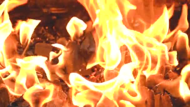 Brandende vlammen van brand in slowmotion tegen de achtergrond van kolen — Stockvideo