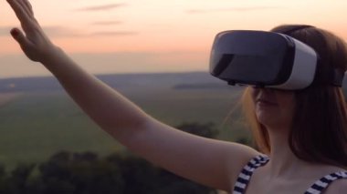 Güzel kız sanal gerçeklik gözlük vr kırmızı günbatımı yavaş kullanır