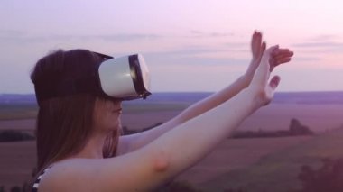Güzel kız sanal gerçeklik gözlük vr scarlet günbatımında kullanır.