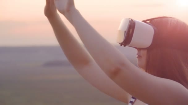 Hermosa chica utiliza gafas de realidad virtual vr en la puesta de sol escarlata en cámara lenta — Vídeos de Stock