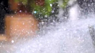 Dekoratif çeşmeden su içinde bir yavaş hareket yakın çekim, su parçacıkları dağılım farklı yönlere sprinkles